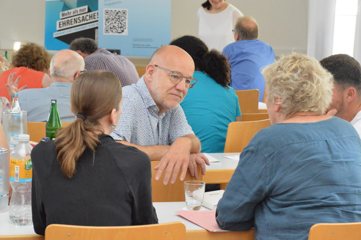 Menschen an Tischen im Gespräch